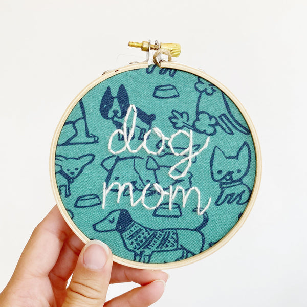 hand-stitched emboroidery with lettering that says dog mom on dog patterned fabric
