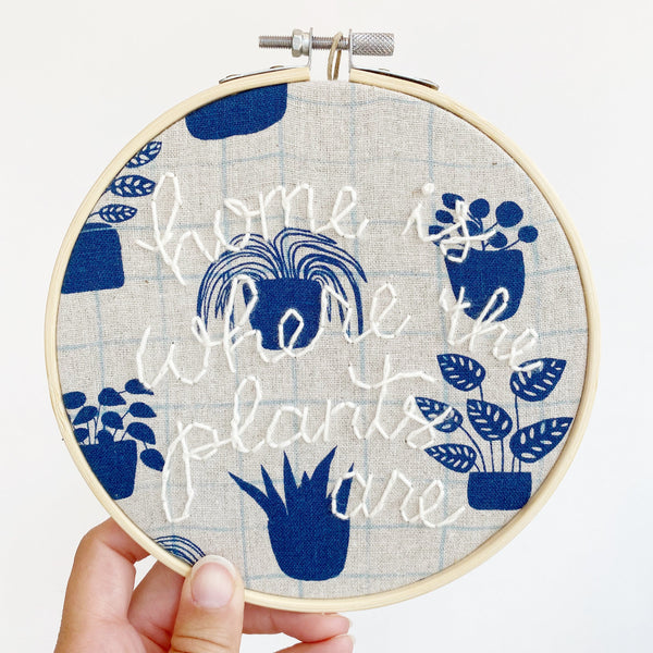 embroidery with hand-stitching that reads home is where the plants are