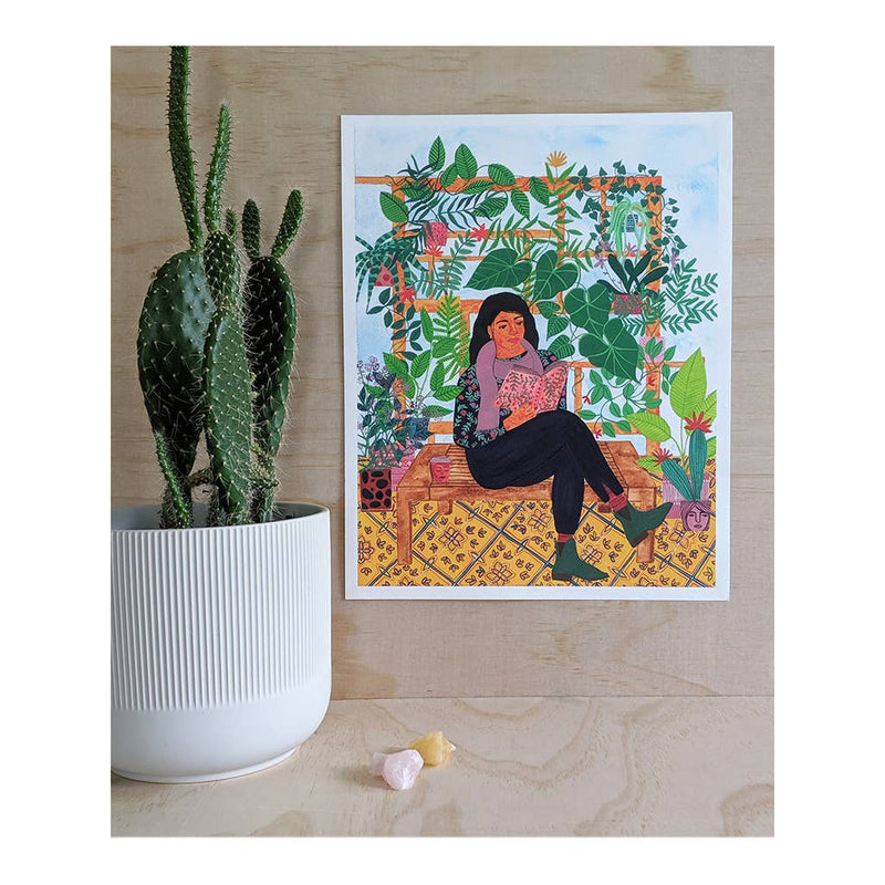 art print featuring woman reading in a garden