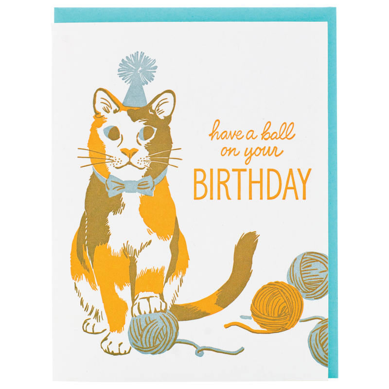 Birthday card with text that reads "have a ball on your birthday" and features a cat with yarn